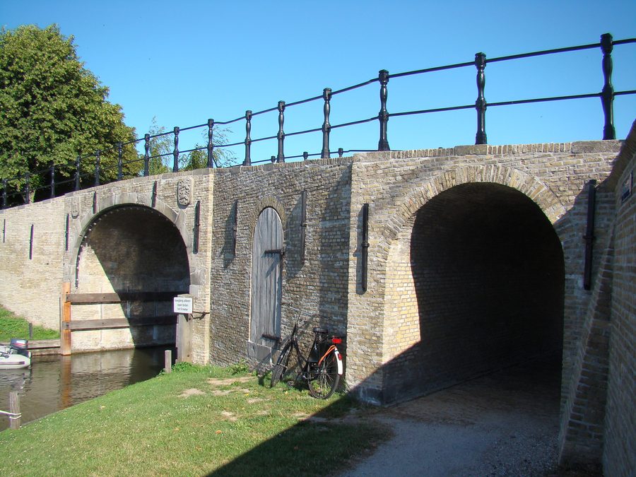 Исторический мост и монументальное здание у Lemsterwaterpoort в Sloten, Friesland