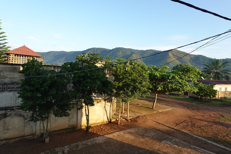 Bergkette bei Kpalimé in Togo mit Häusern und Straße im Vordergrund