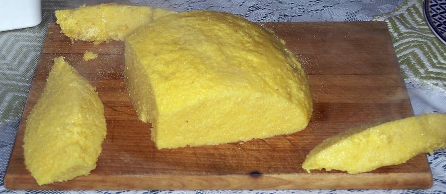 Подача мамалыги — густой румынской кукурузной каши — на тарелке.