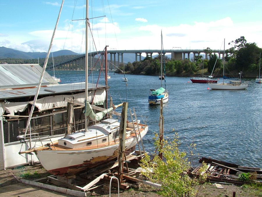 Blick über Montagu Bay in Tasmanien mit einer Yacht auf dem Trockendock und der Tasman Bridge im Hintergrund