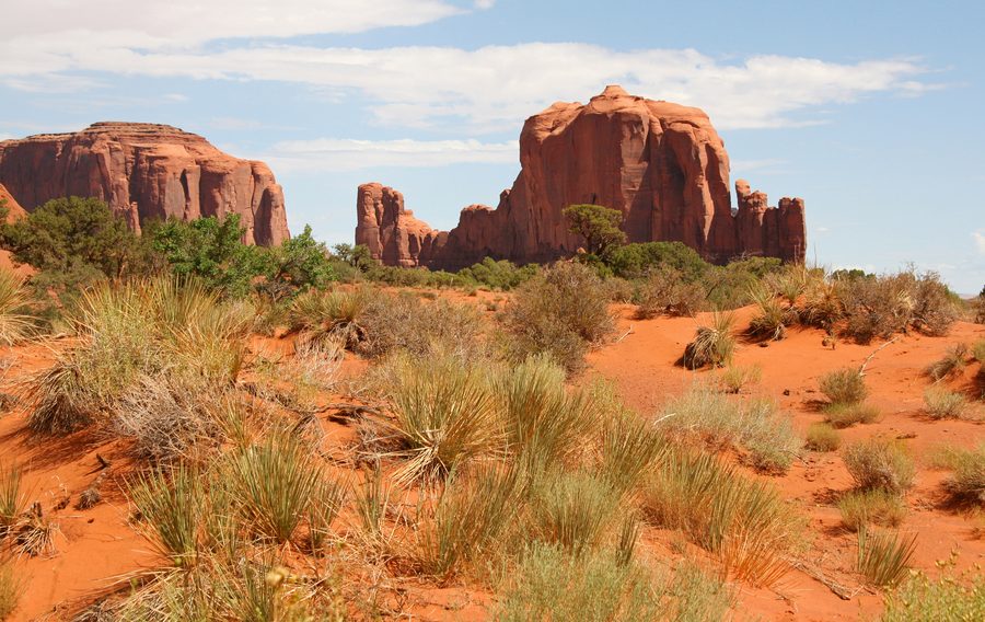 Месы и останцовые скалы Monument Valley в Аризоне под голубым небом.
