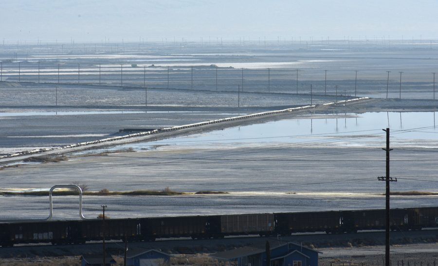 Вид на высохшее озеро Сёрлс в Троне, Калифорния, с холмами и поездом на переднем плане