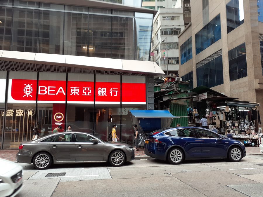 Уличная сцена на Queen's Road Central в Гонконге с отделением Bank of East Asia.