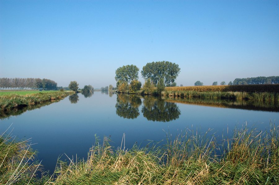 Вид на Hollandersgatkreek в Синт-Лаурейнсе с плоским польдерным ландшафтом