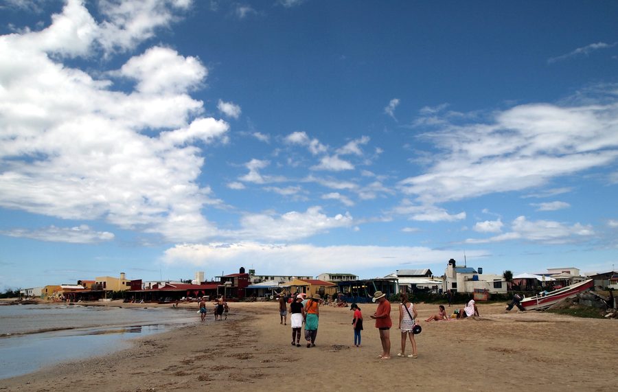 Sandstrand und Meer bei Cabo Polonio in Rocha, Uruguay, unter blauem Himmel mit Wolken.