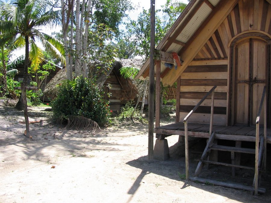 Wooden houses beside a river in Suriname's rainforest.