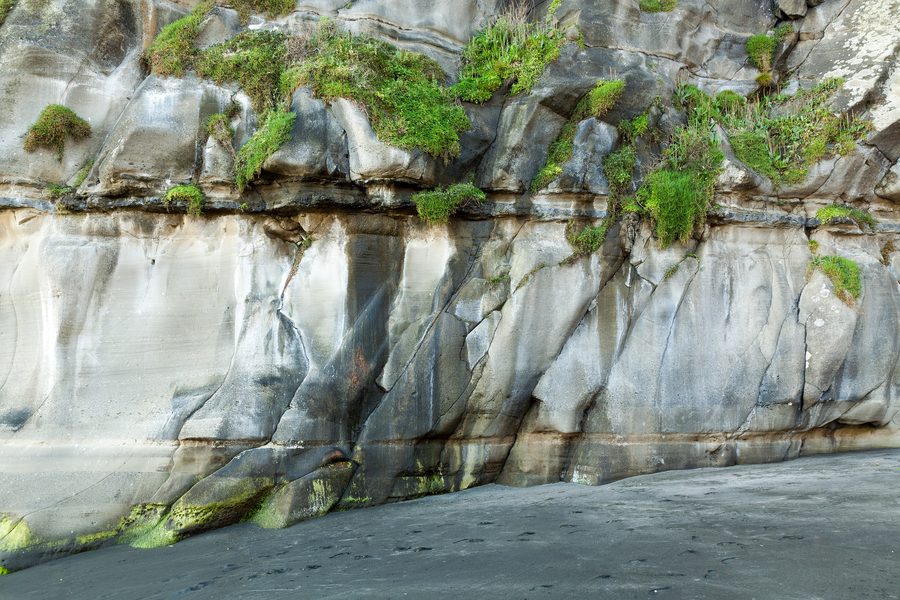 Скалы на пляже Muriwai Beach на западном побережье у Окленда
